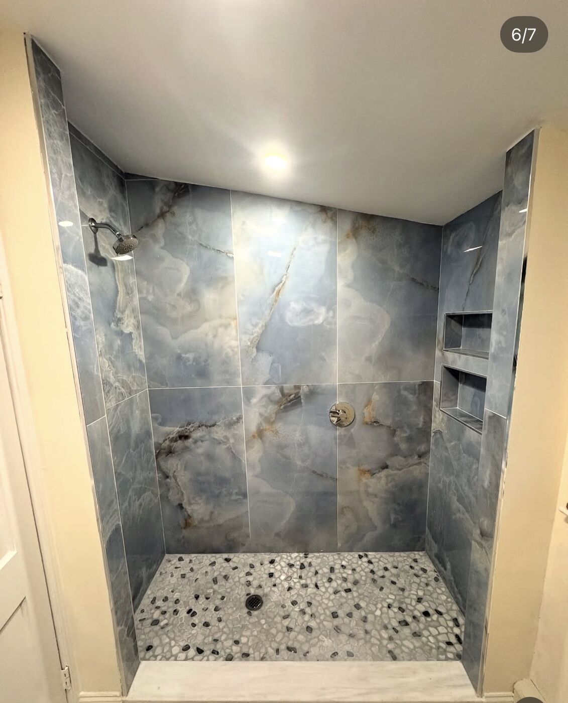 Finished blue onyx walk-in shower with pebble floor